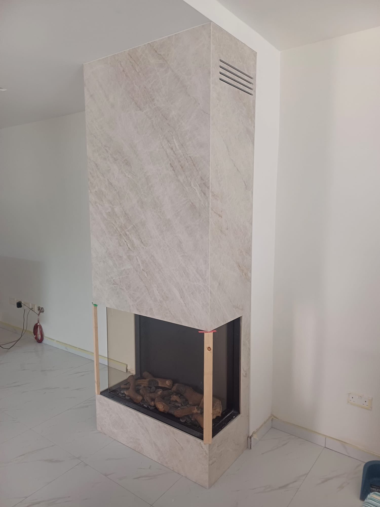 A living area featuring a marble-clad fireplace installation in a bright interior.