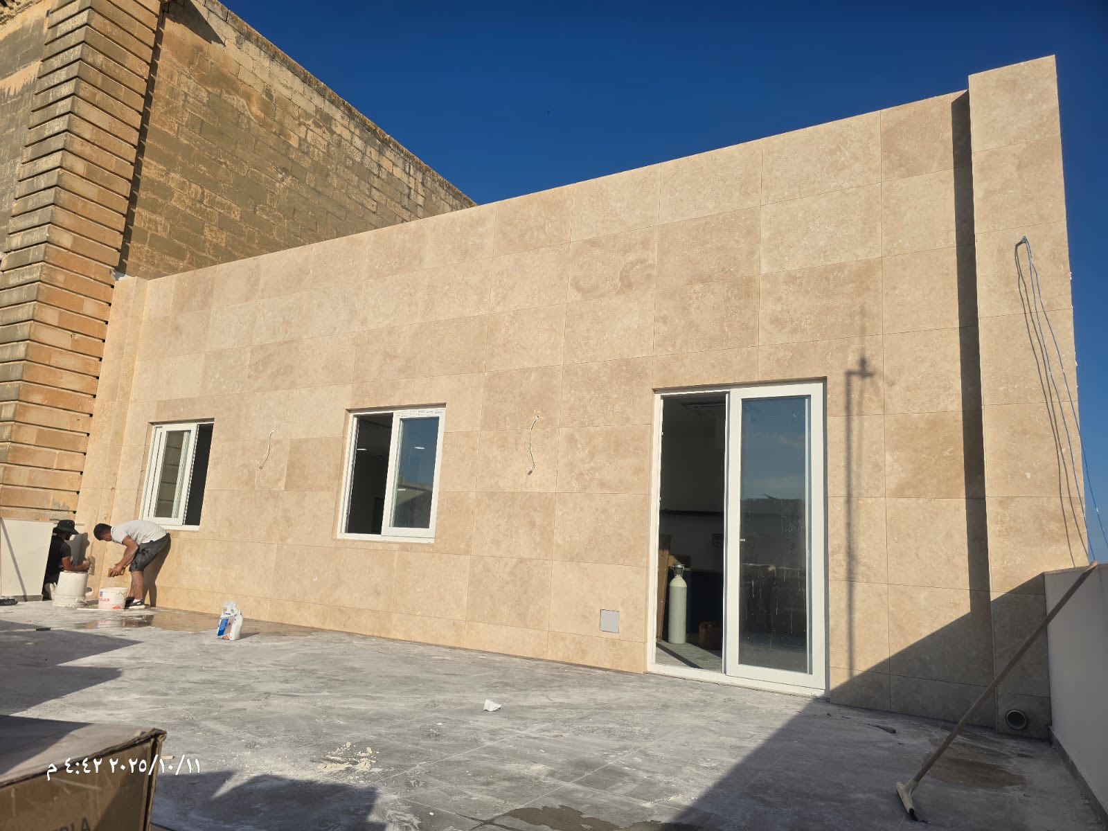 An outdoor facade and terrace area finished with large-format stone-look cladding.